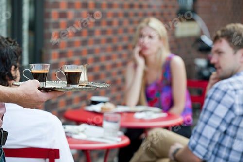 Preview: Waiter with coffee for people outside cafe