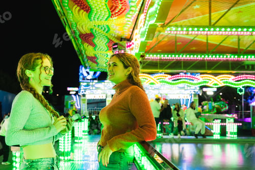 Preview: Young friends enjoying fun fair amusement park night