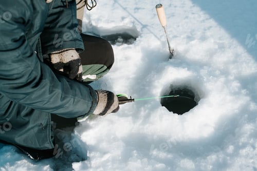 Preview: Winter fishing, active leisure, hobbies, sports and recreation concept. Close-up of male fisherman