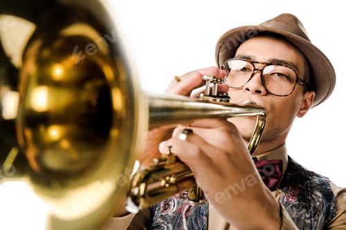 Preview: selective focus of young mixed race man in stylish hat and eyeglasses playing on trumpet isolated on