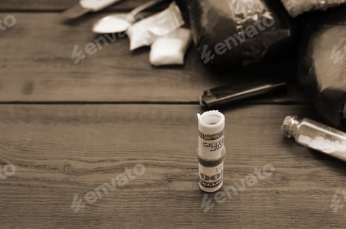 Preview: Roll of hundred dollar bills on background of narcotic drug dealer stuff
