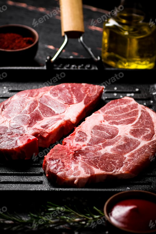 Preview: Raw steak pork in a grill pan with tomato sauce and spices.