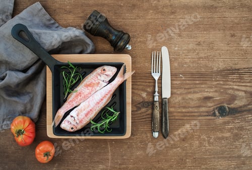 Preview: Raw uncooked Red Mullet fish in a cooking pan with rosemary, lemon and garlic