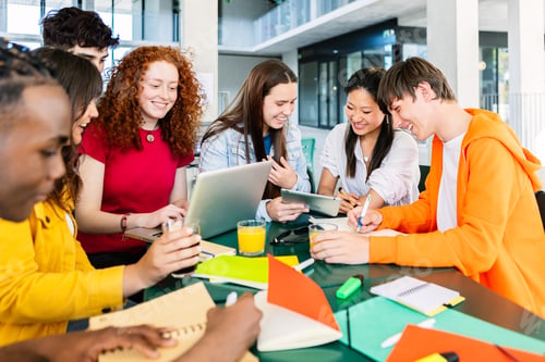 Preview: Young group of high school students studying together at cafeteria campus table