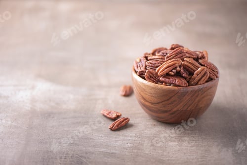 Preview: Pecan nuts in wooden bowl on wood textured background. Copy space. Superfood, vegan, vegetarian food
