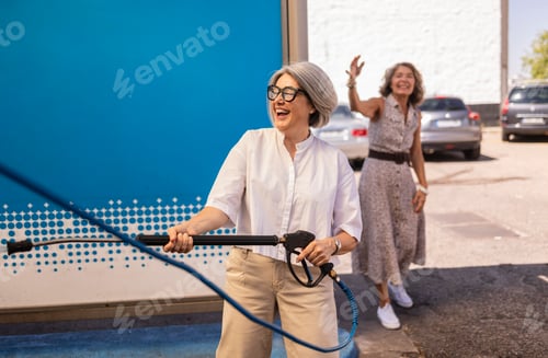 Preview: Mature women friends laughing washing car together