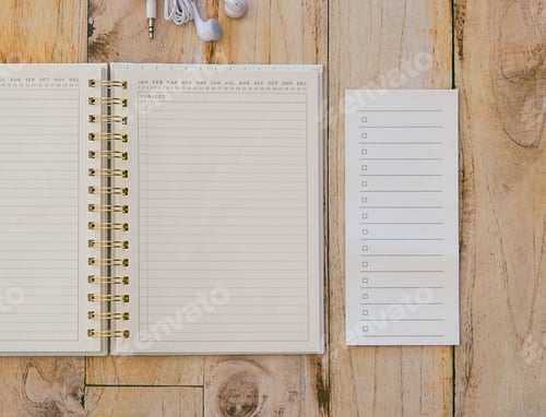 Preview: Overhead view of an open lined journal and lined notepad with check boxes on a wooden background