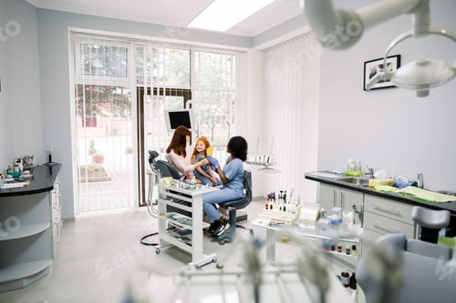 Preview: Modern dentist's office. Mother and little daughter having a regular check up