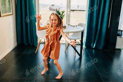 Preview: Little kid happy girl dancing on the kitchen at cozy home lifestyle authentic moment