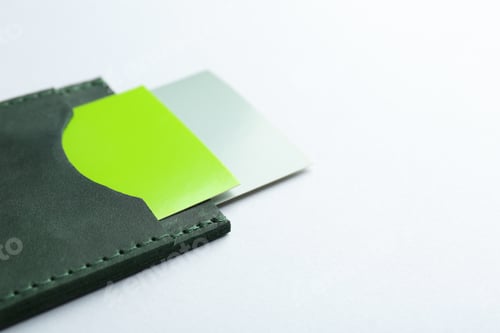 Preview: Leather business card holder with colorful cards on light grey background, closeup. Space for text