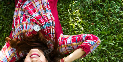 Preview: Indian woman is lying on the green grass