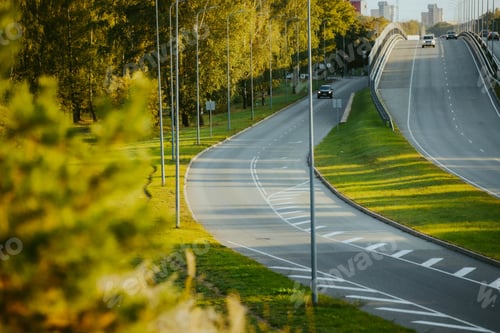 Preview: Top view of cars driving along a highway road in the evening time under a sunny blue sky