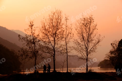Preview: Rear view of tourist near lake at sunset