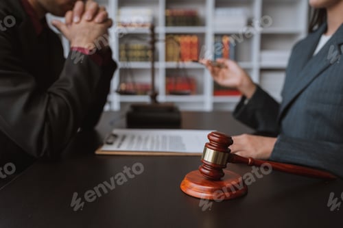 Preview: Young businessman concentrating on signing a contract with a skilled female lawyer and financial adv