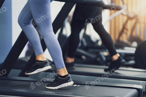 Preview: Legs of two girl friends working out on treadmill
