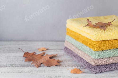 Preview: Stack of colorful bath towels on light background.