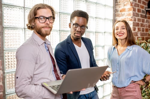 Preview: Group of young business people standing in the loft office