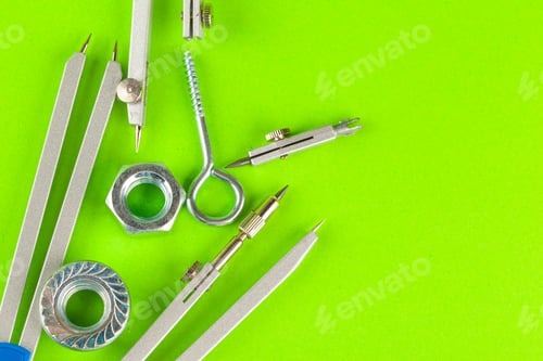 Preview: Top view of stainless steel bolts or iron nails on bright green background