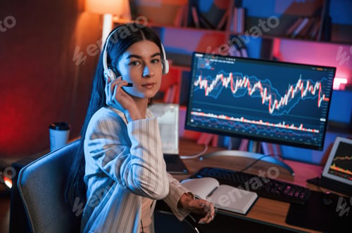 Preview: Female stock trader is working by pc indoors. Conception of exchange and money
