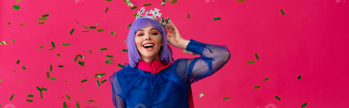 Preview: panoramic shot of excited attractive pop art girl in purple wig and crown on party with confetti,