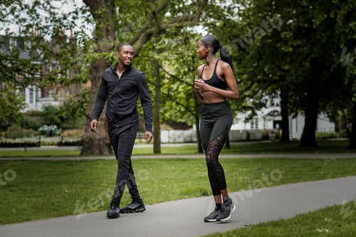 Preview: Black brother and sister twins doing exercise outdoors in stylish sportswear.
