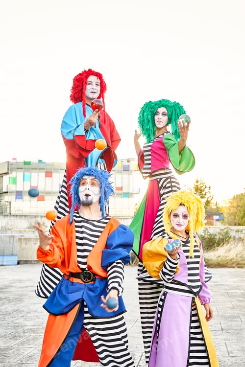 Preview: Group of harlequins in colorful costumes holding crystal balls.