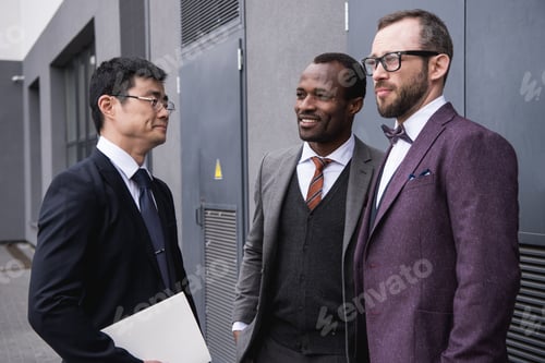 Preview: business people discussing work together near modern office building