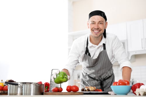 Preview: Professional chef in uniform working at restaurant kitchen