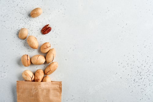 Preview: Nuts pecan in paper bag on white background with copy space. Snack vegan sugarfree food.