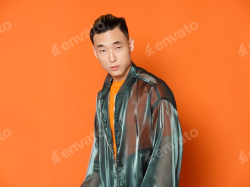 Preview: Asian man wearing orange t-shirt over isolated background and gray jacket model