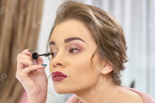 Preview: Woman using eyelash brush
