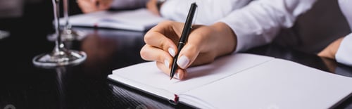 Preview: Panoramic shot of sommelier writing on notebook near glasses in restaurant