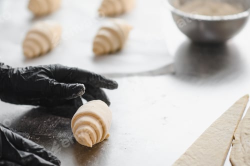 Preview: Baker making croissants in bakery: placing dough on stainless steel table