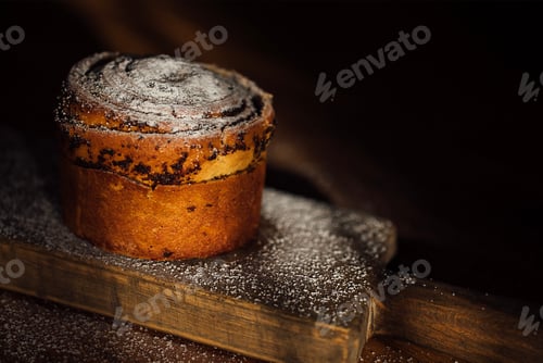 Preview: Chocolate swirl pastry dusted with powdered sugar on a wooden board