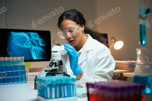 Preview: Female scientist researching DNA with microscope in laboratory