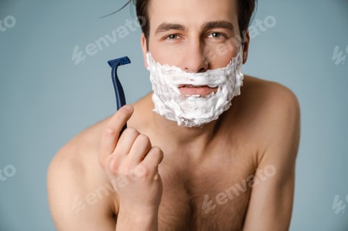 Preview: Shirtless white man looking at camera while shaving with foam