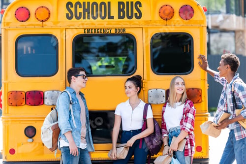 Preview: group of teen scholars chatting while leaning on school bus