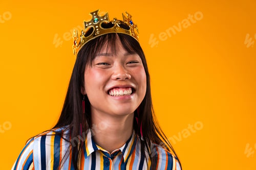 Preview: Beautiful asian woman portrait, young asian woman wearing crown smiling on yellow background