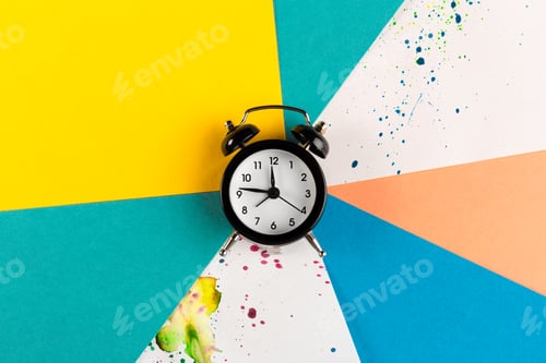 Preview: Vintage alarm clock on a creative colorful background with paint sprinkles