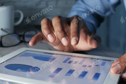 Preview: young man hand analyzing financial data and chart on digital tablet