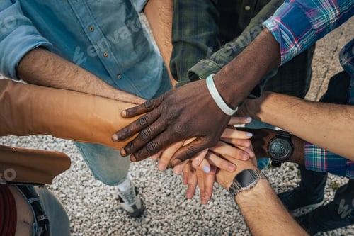 Preview: Diverse group teamwork joining hands outdoors in unity and support