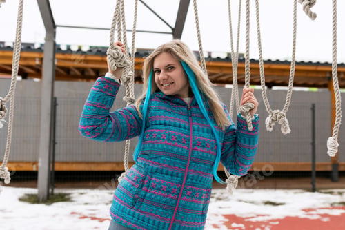 Preview: European woman with blond hair enjoys a day off while walking on the street in winter