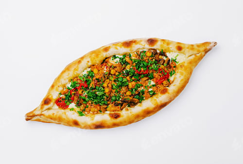Preview: Delicious pide filled with fresh vegetables and herbs served on a white background