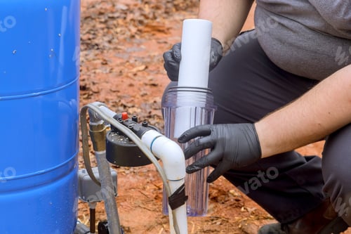 Preview: Installation of new water purification filter cartridge by a maintenance serviceman