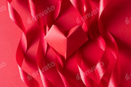 Preview: Bright pink color curl satin ribbon and origami heart on paper background
