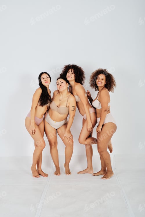 Preview: Carefree young fit and obese multiethnic ladies smiling in studio