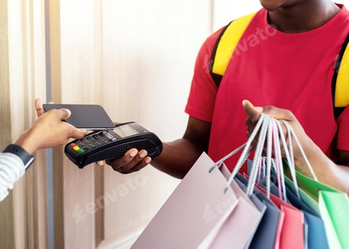 Preview: Black Lady Paying Courier Putting Phone To Payment Terminal Indoor
