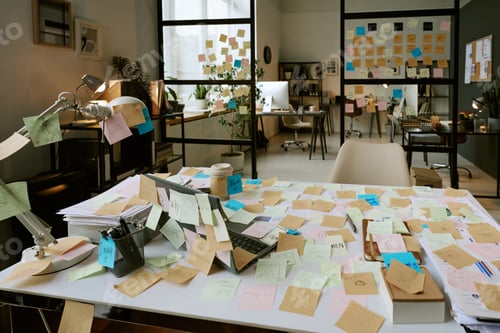 Preview: Messy Office Desk with Sticky Notes and Laptop Representing Busy Workday