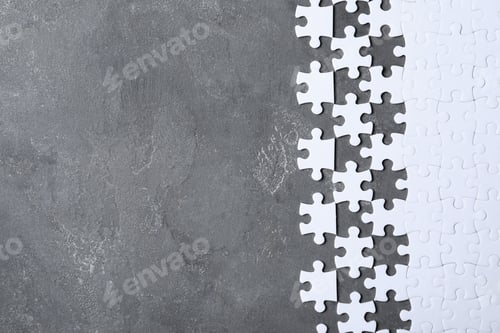 Preview: Blank white puzzle pieces on grey stone background, flat lay. Space for text