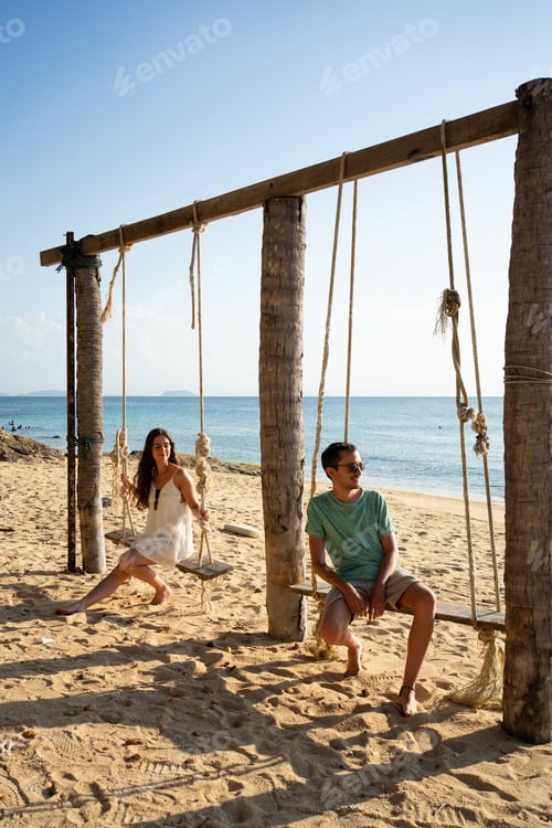 Preview: Couple relaxing on beach swing enjoying summer vacation